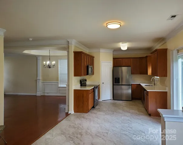 a kitchen with stainless steel appliances kitchen island granite countertop a refrigerator and a stove top oven