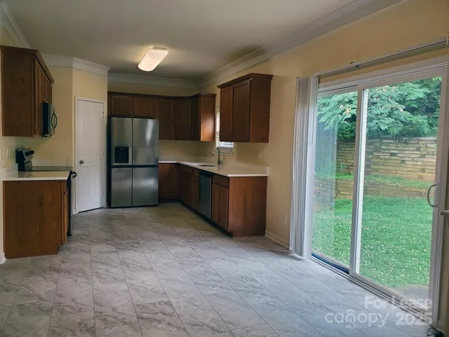 a kitchen with kitchen island a counter top space cabinets and stainless steel appliances