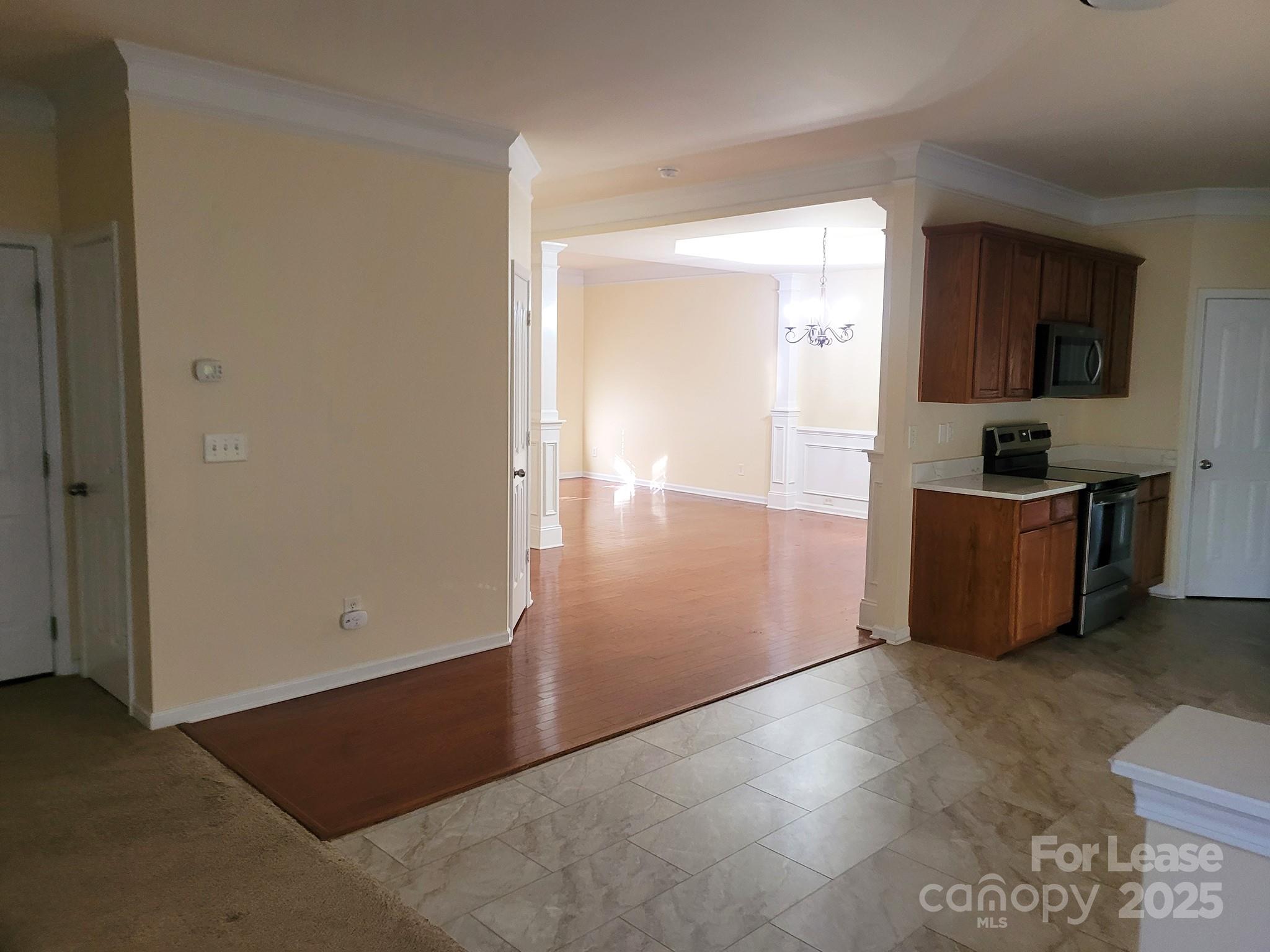 13008 Rothe House Road Charlotte, NC 28273 - Photo 10 of 26 a view of an empty room with wooden floor and a bathroom