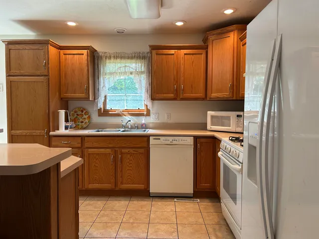 a kitchen with stainless steel appliances granite countertop a refrigerator and a sink