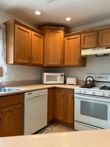 a kitchen with stainless steel appliances granite countertop a stove a sink and cabinets