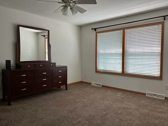 an empty room with a window and a dresser