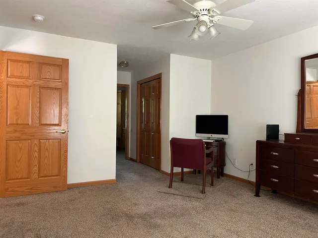 a view of a workspace with furniture and a window