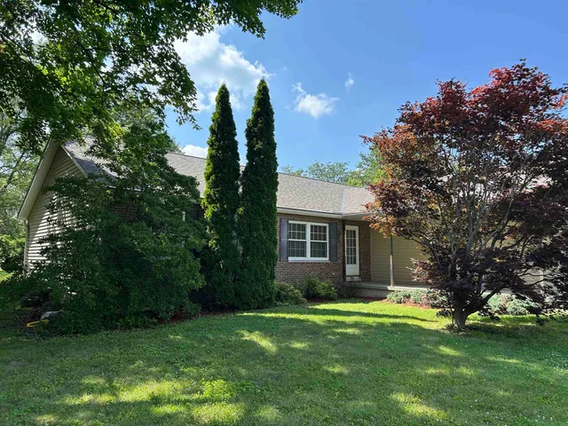 a view of backyard of house with green space