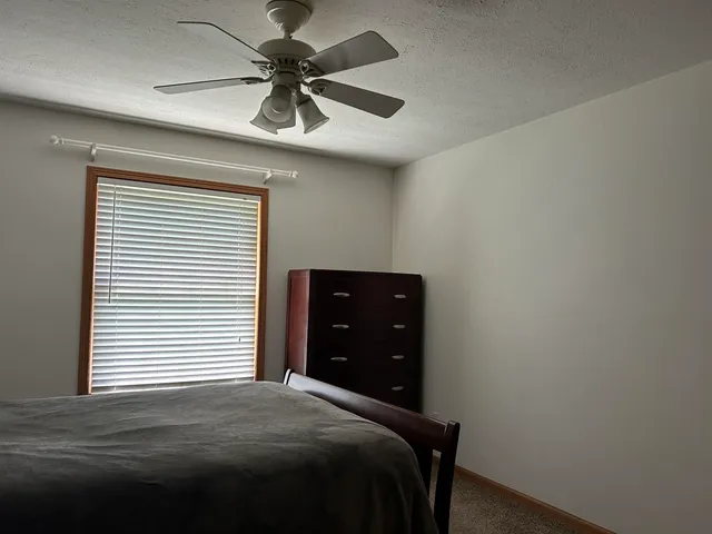 a bedroom with a bed and a ceiling fan
