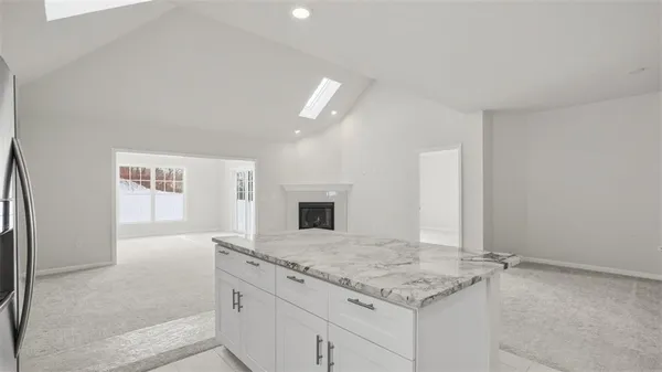 an empty room with windows and fireplace