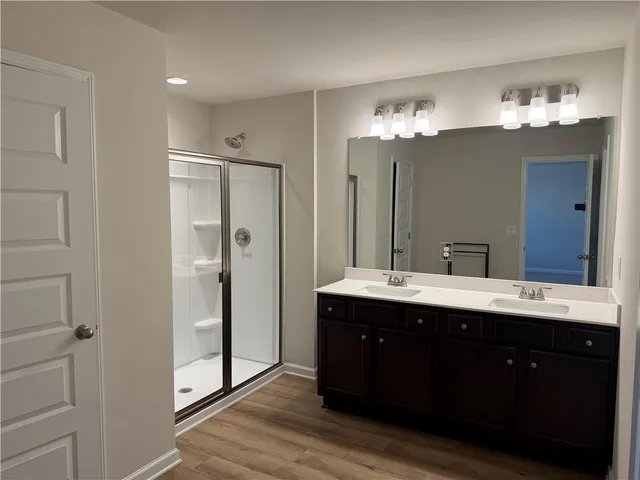 a spacious bathroom with a double vanity sink mirror and shower