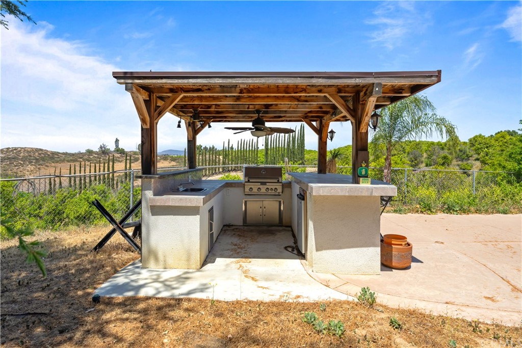 34970 Santa Rita Road Temecula, CA 92592 - Photo 19 of 38 a view of a patio with a table and chairs under an umbrella