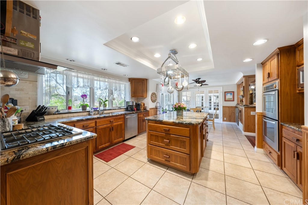 34970 Santa Rita Road Temecula, CA 92592 - Photo 21 of 38 a kitchen with stainless steel appliances kitchen island granite countertop a stove a sink and a refrigerator