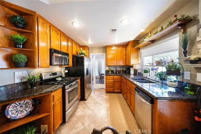 a large kitchen with stainless steel appliances granite countertop a stove a sink and a refrigerator