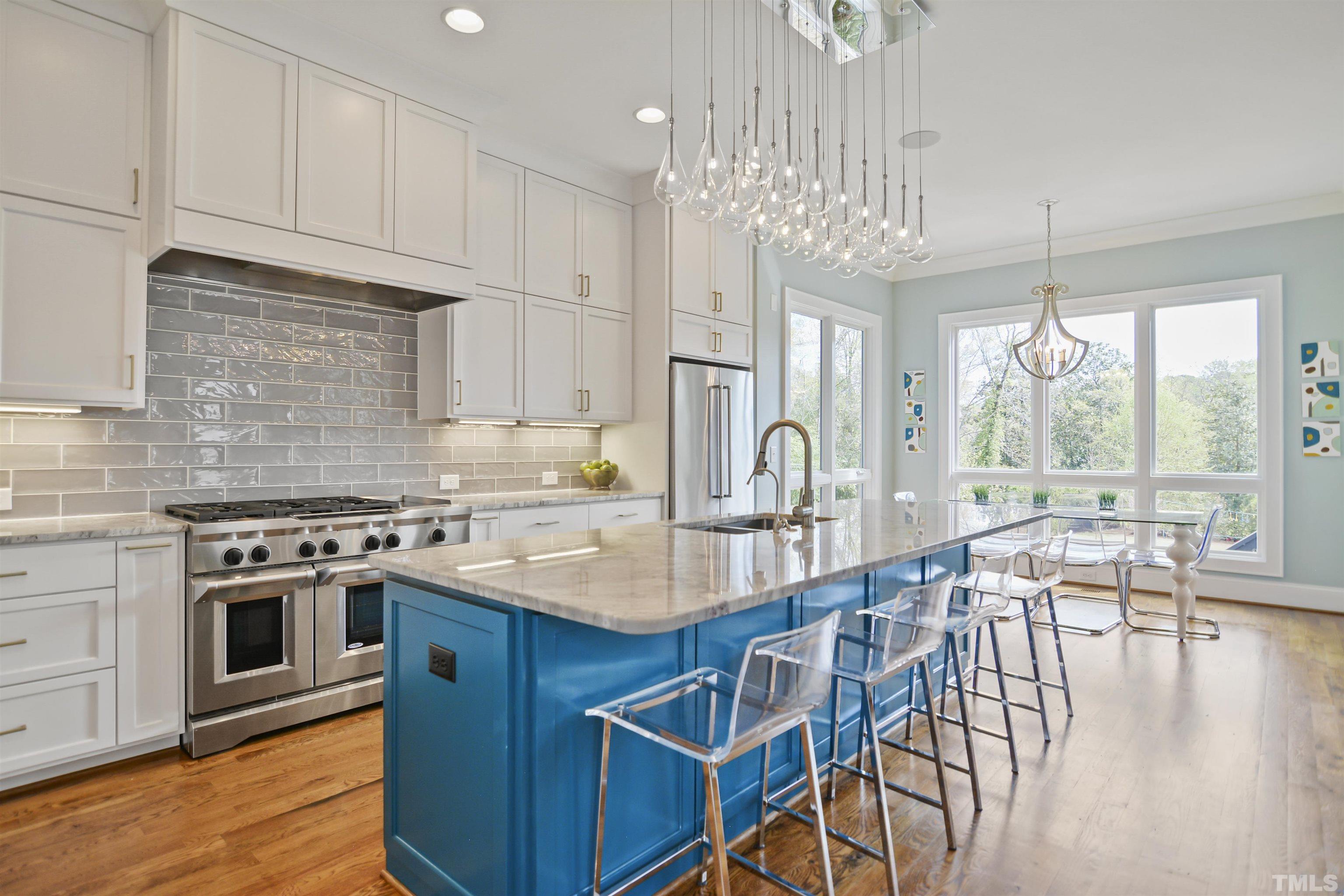 1012 Canterbury Road Raleigh, NC 27607 - Photo 13 of 51 a kitchen with stainless steel appliances granite countertop a stove top oven a sink a dining table and chairs with wooden floor