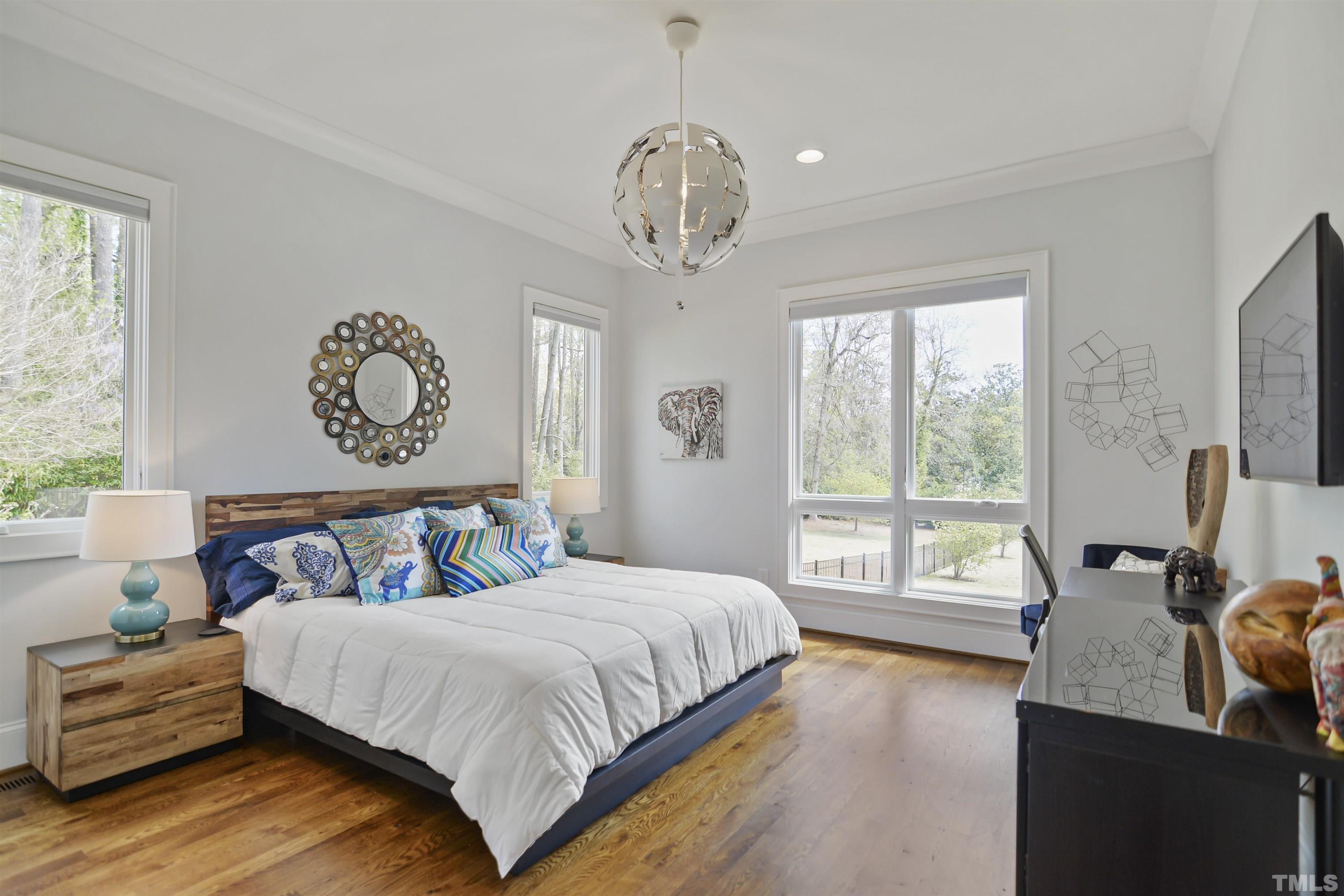 1012 Canterbury Road Raleigh, NC 27607 - Photo 33 of 51 a bedroom with a bed and a chandelier
