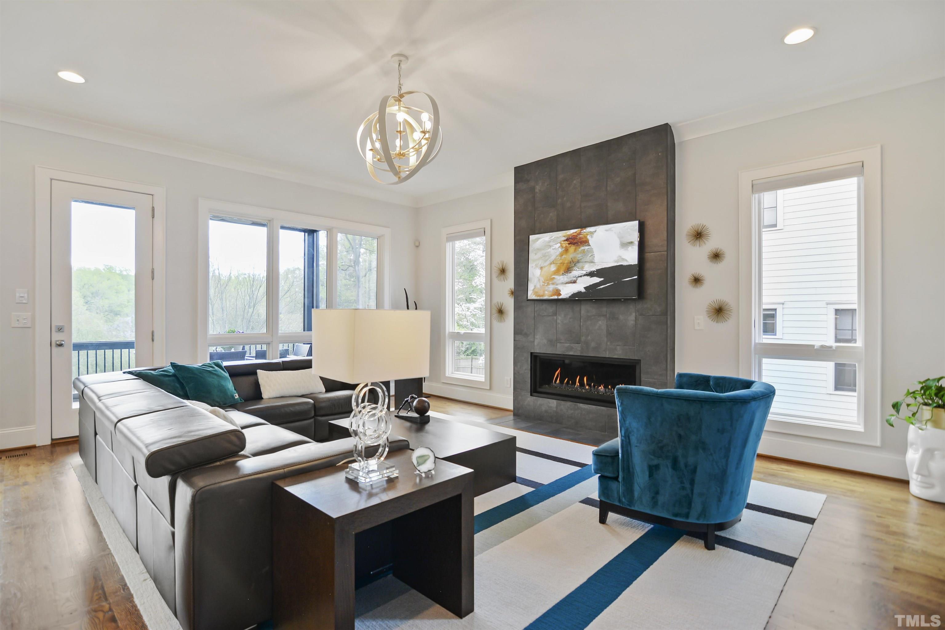 1012 Canterbury Road Raleigh, NC 27607 - Photo 8 of 51 a living room with furniture a fireplace and a large window