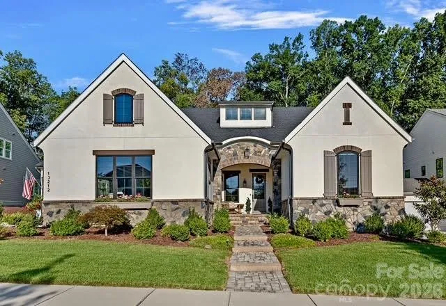 a front view of a house with a yard and a garage