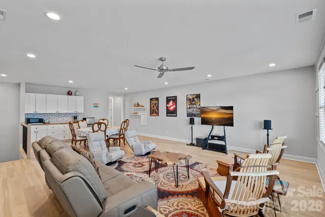 a living room with lots of furniture and view of kitchen