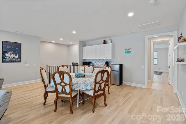 a kitchen with stainless steel appliances granite countertop a dining table and chairs with wooden floor