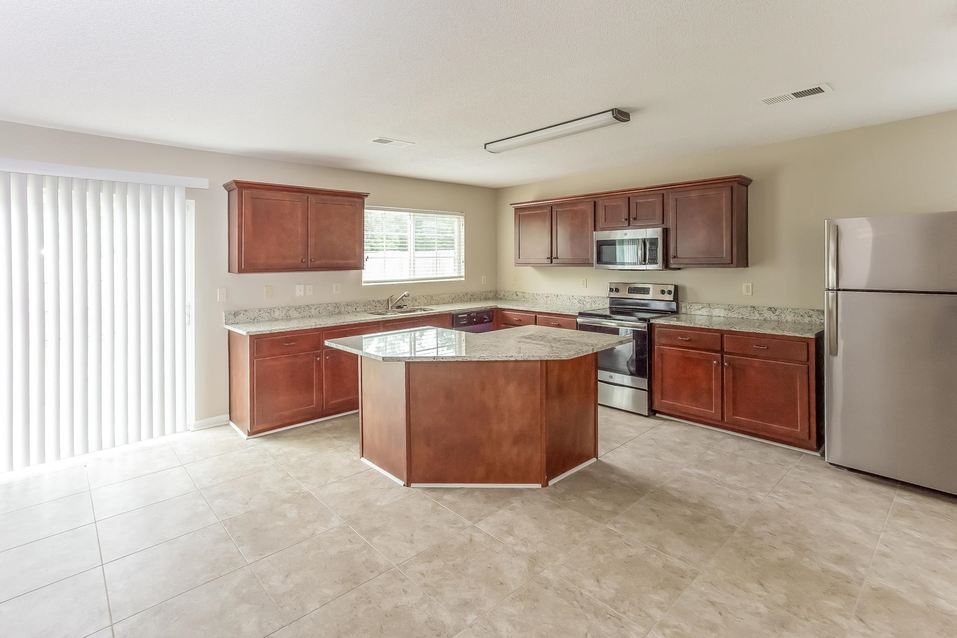 9966 Chariden Drive Cordova, TN 38016 - Photo 5 of 17 a kitchen with stainless steel appliances granite countertop a stove a sink a refrigerator a microwave oven and a cabinets