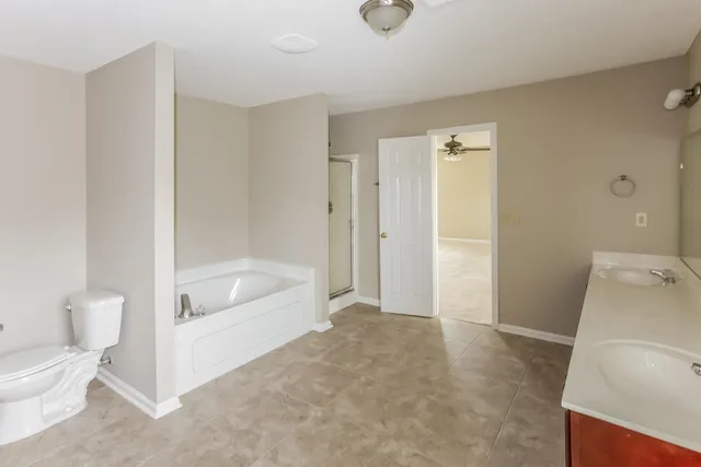 a bathroom with a tub shower and a toilet