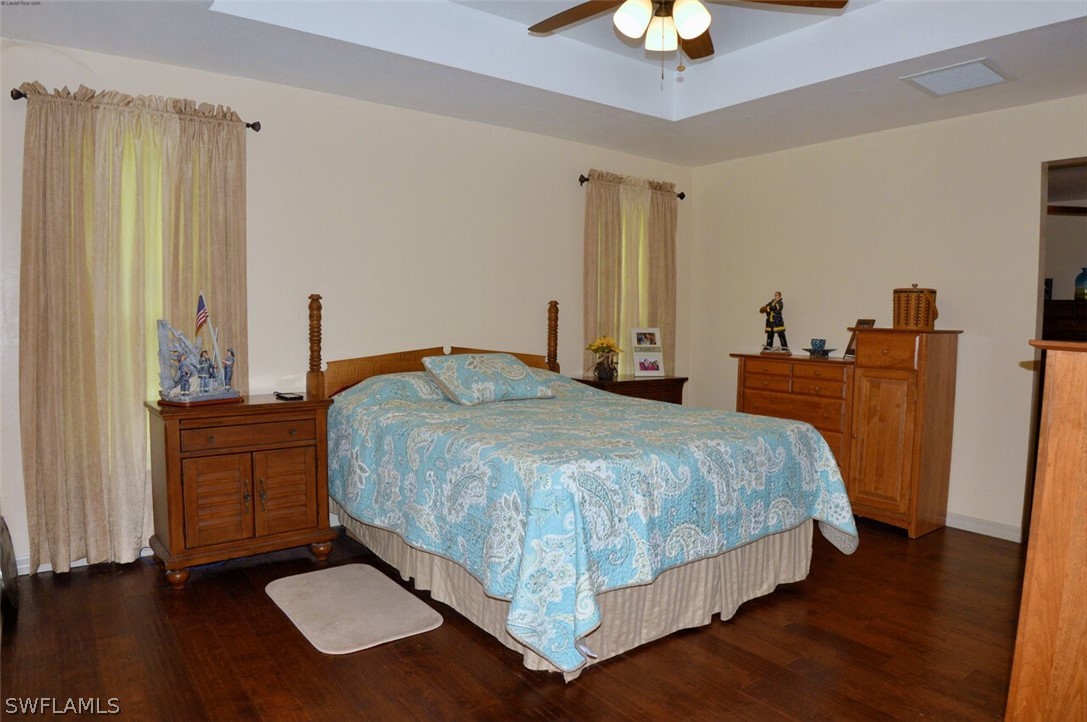 2041 Rialto Way Alva, FL 33920 - Photo 13 of 32 a bedroom with a bed and a chandelier