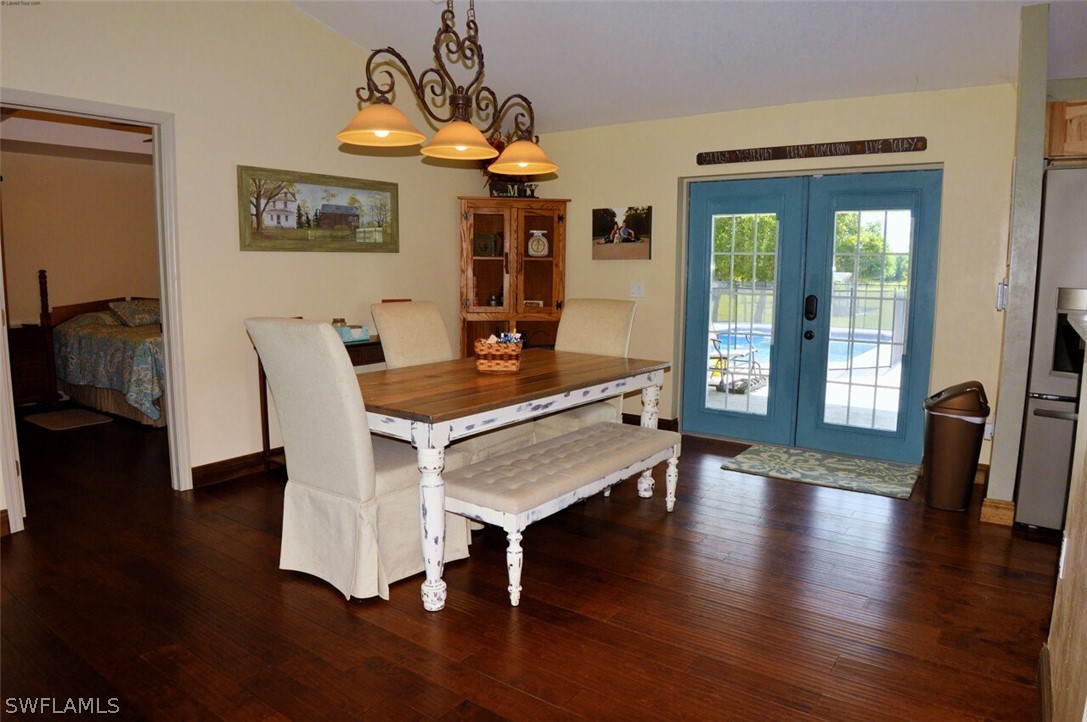 2041 Rialto Way Alva, FL 33920 - Photo 8 of 32 a dining room with wooden floor a chandelier a glass table and chairs