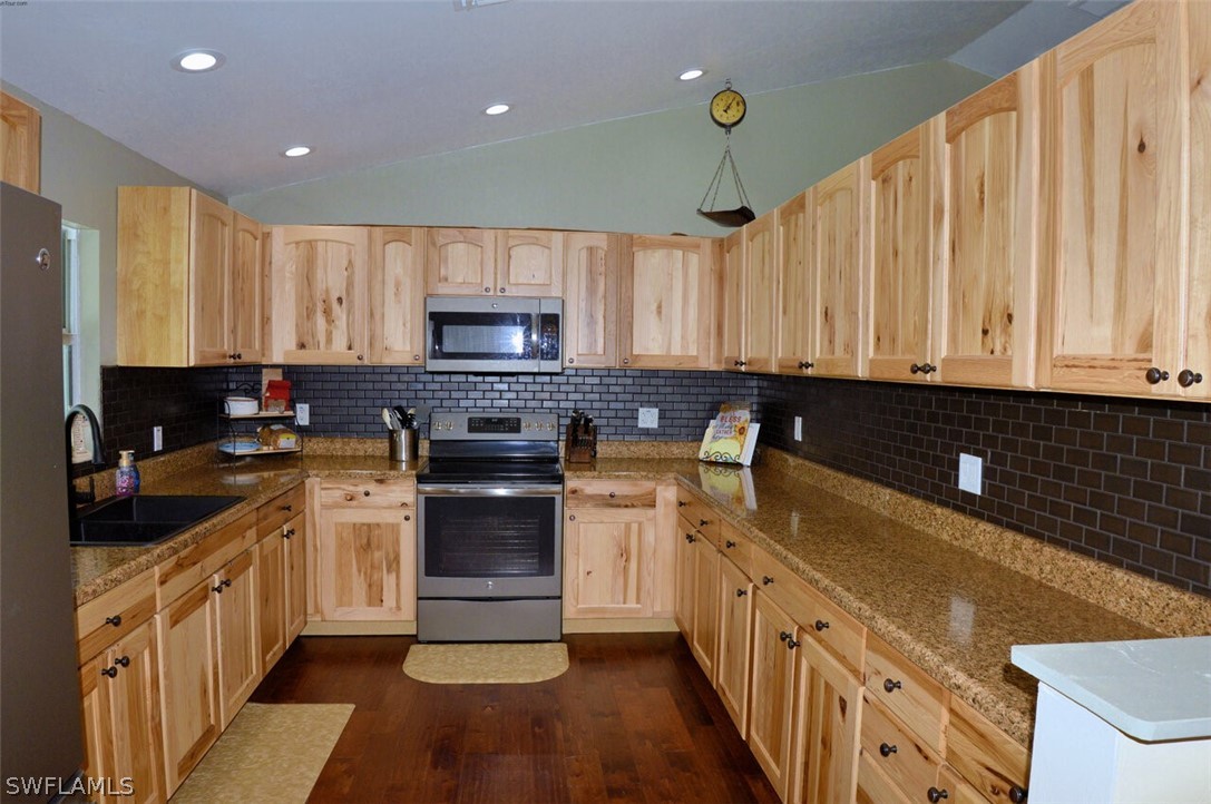 2041 Rialto Way Alva, FL 33920 - Photo 9 of 32 a kitchen with stainless steel appliances granite countertop a stove a sink and a refrigerator