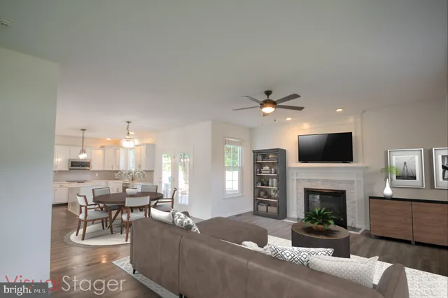 a view of an empty room with wooden floor and a fireplace