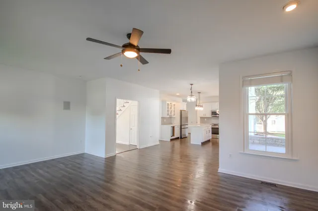 a large kitchen with lots of counter space wooden floor appliances and furniture
