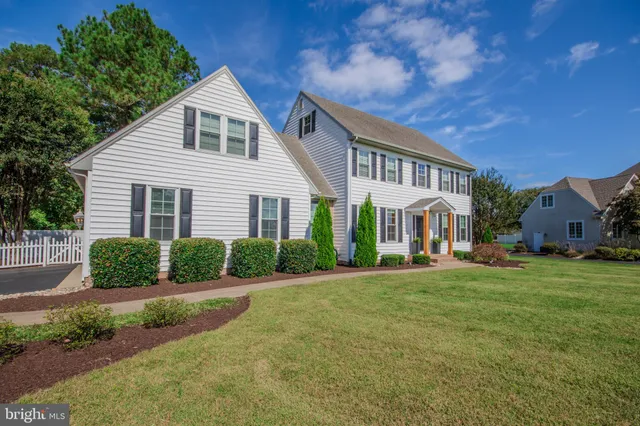 a front view of a house with a yard and potted plants