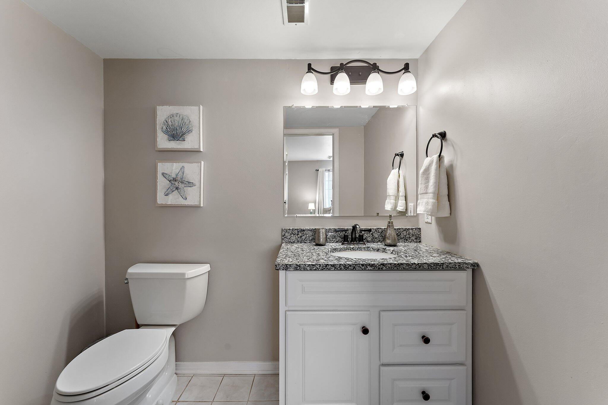 406 Sturdy Road, Unit 1A Valparaiso, IN 46383 - Photo 11 of 16 a bathroom with a granite countertop toilet sink and mirror