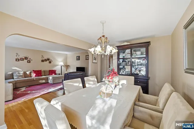 a kitchen with stainless steel appliances kitchen island granite countertop a refrigerator a stove top oven a sink dishwasher and white cabinets with wooden floor