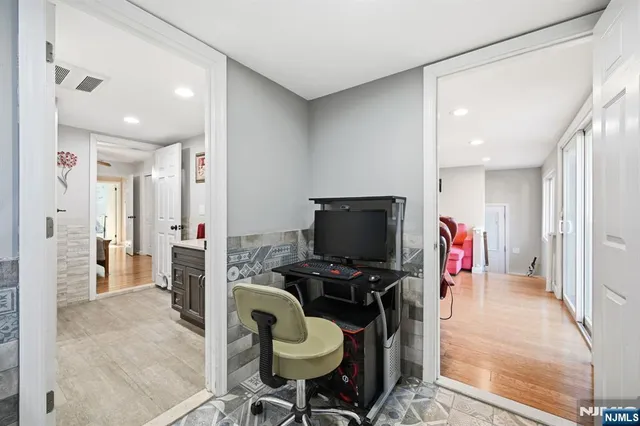 a bedroom with filled bed and wooden floor