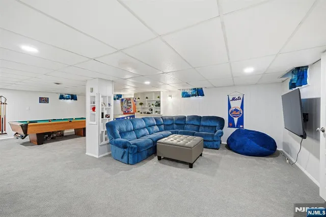 a bathroom with a toilet a sink a mirror and a window