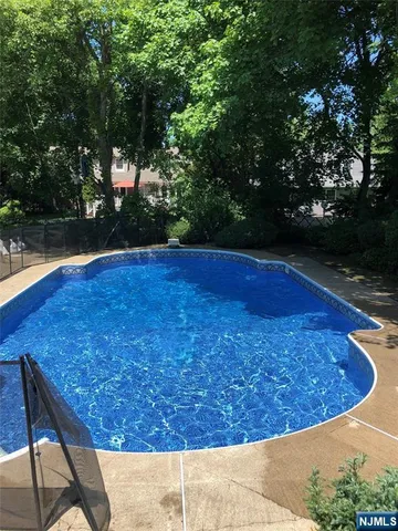a view of water pool and trees in the background