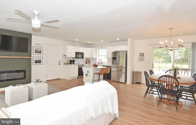 a living room with stainless steel appliances kitchen island granite countertop furniture and fireplace