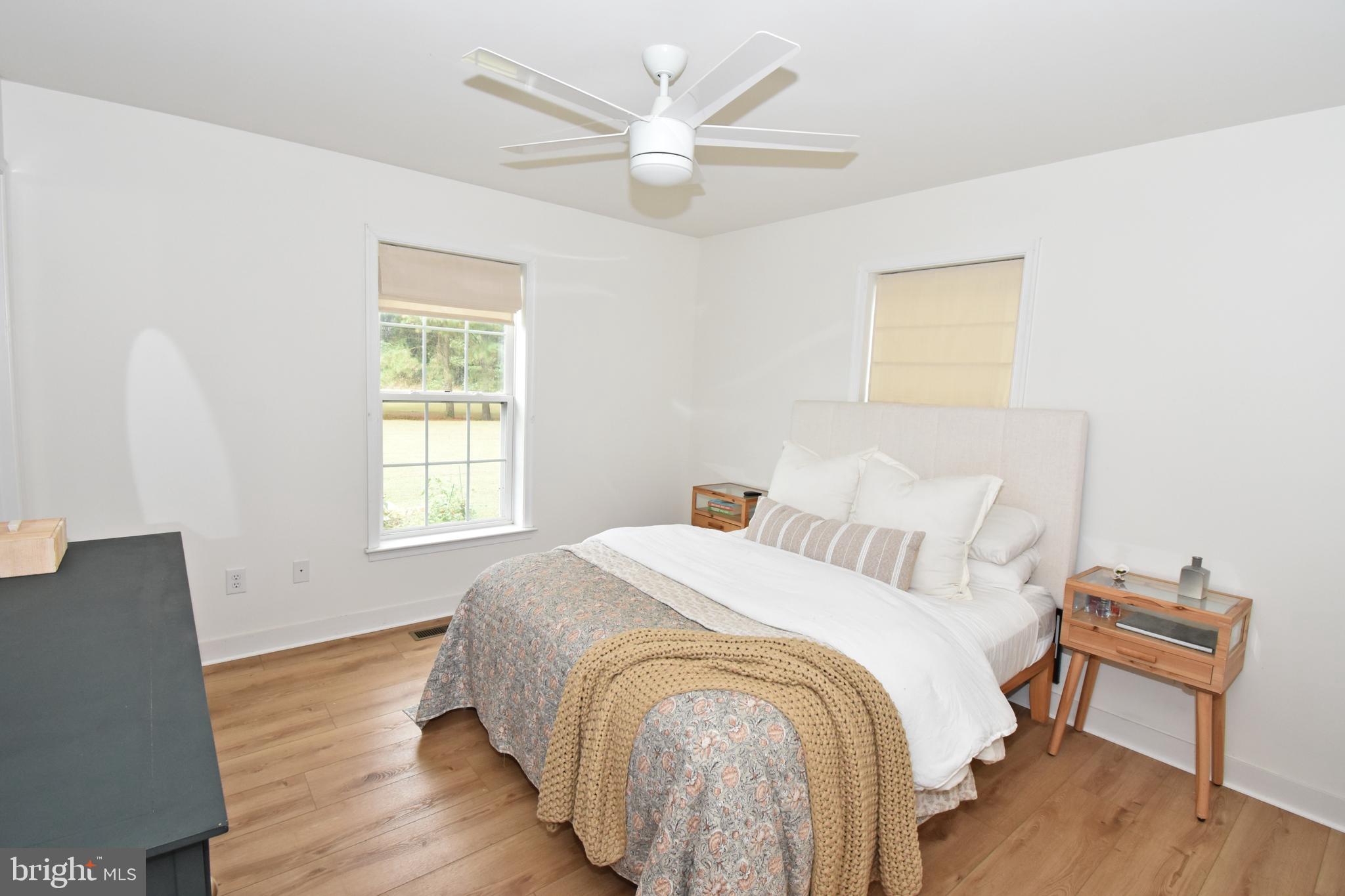 6600 Old Westover Marion Road Westover, MD 21871 - Photo 21 of 52 a spacious bedroom with a bed and a chair with wooden floor