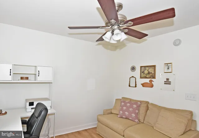 a view of a workspace with furniture and a window