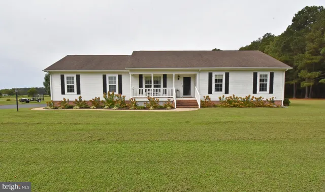 a front view of a house with a garden and trees