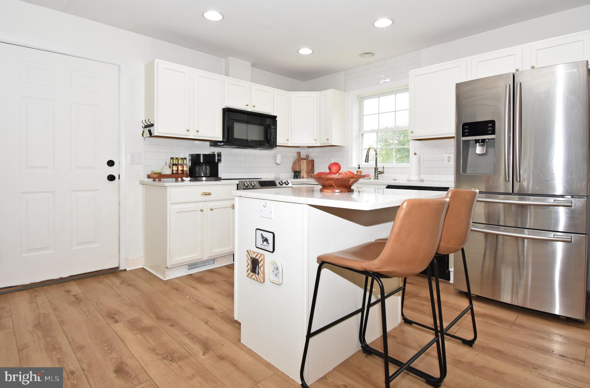 6600 Old Westover Marion Road Westover, MD 21871 - Photo 7 of 52 a kitchen with stainless steel appliances a microwave a stove a refrigerator cabinets and wooden floor