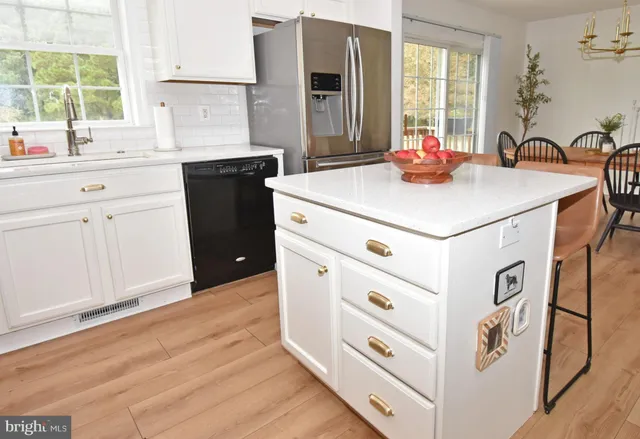 a kitchen with stainless steel appliances a sink cabinets and a window