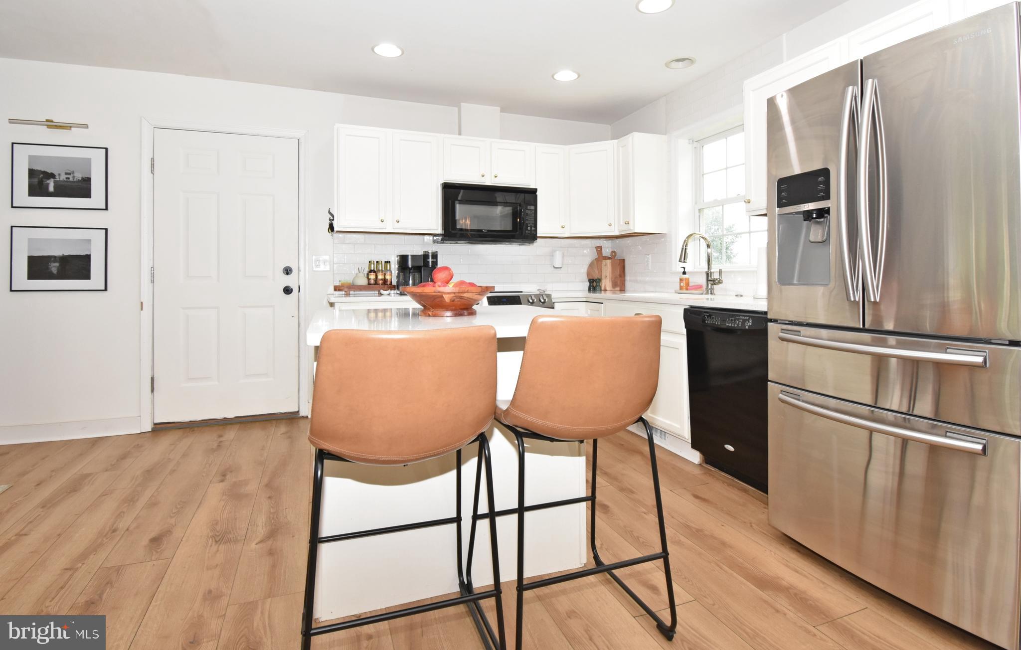 6600 Old Westover Marion Road Westover, MD 21871 - Photo 9 of 52 a kitchen with stainless steel appliances granite countertop a refrigerator a stove a sink dishwasher and a microwave with wooden floor