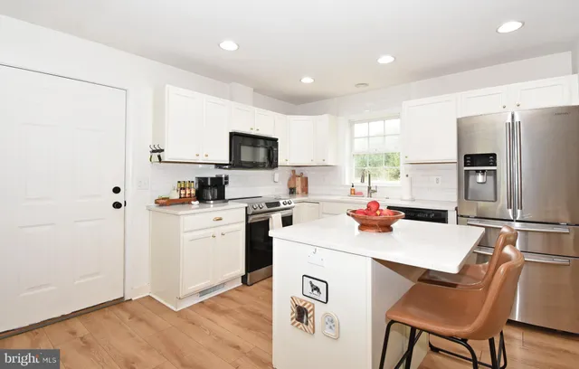 a kitchen with a sink a microwave a refrigerator and white appliances