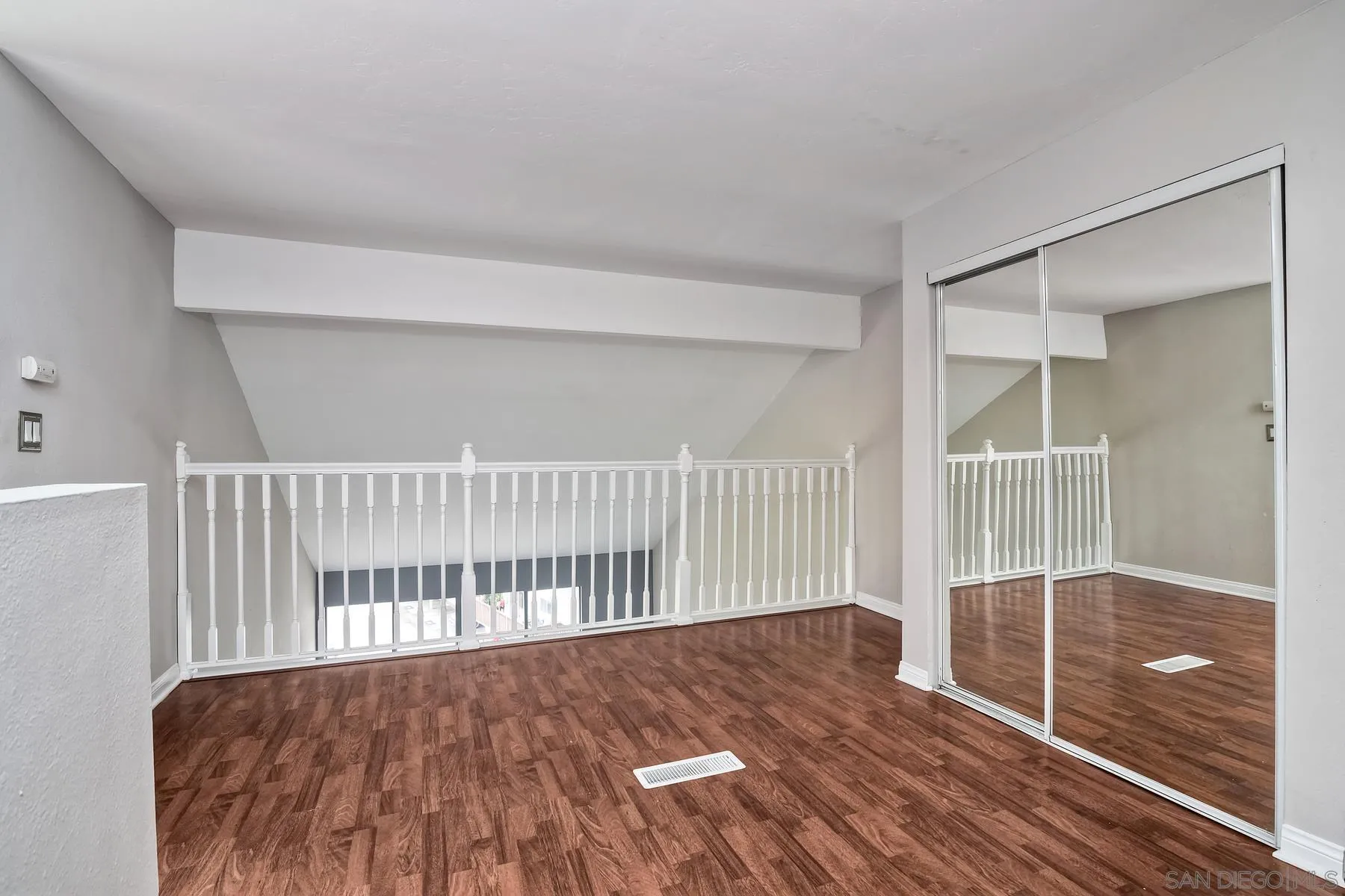 6151 Rancho Mission Road, Unit 317 San Diego, CA 92108 - Photo 16 of 31 a view of an empty room with wooden floor and a window