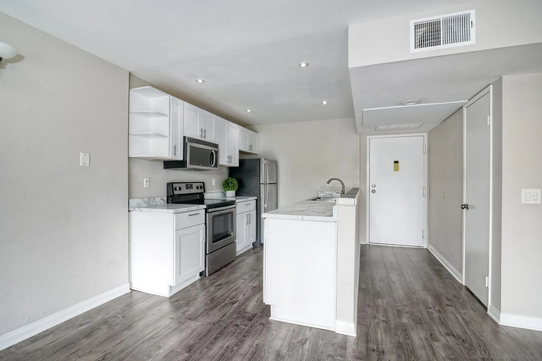 6151 Rancho Mission Road, Unit 317 San Diego, CA 92108 - Photo 5 of 31 a kitchen with cabinets and wooden floor