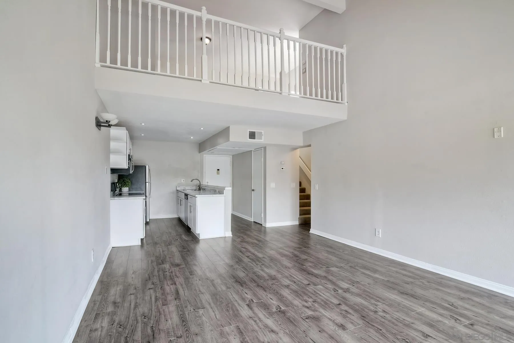 6151 Rancho Mission Road, Unit 317 San Diego, CA 92108 - Photo 6 of 31 a view of a hallway with wooden floor and staircase