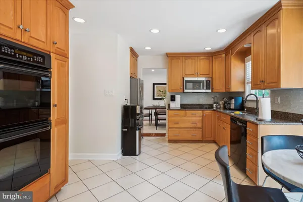 a kitchen with granite countertop a refrigerator stove top oven and cabinets