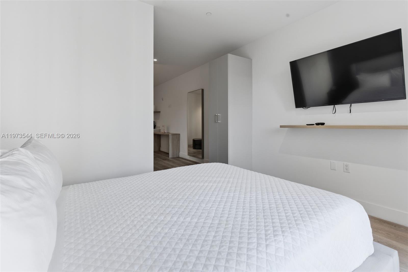 229 Southwest 9th Street, Unit 407 Miami, FL 33130 - Photo 21 of 29 a bedroom with a flat screen tv and a bed