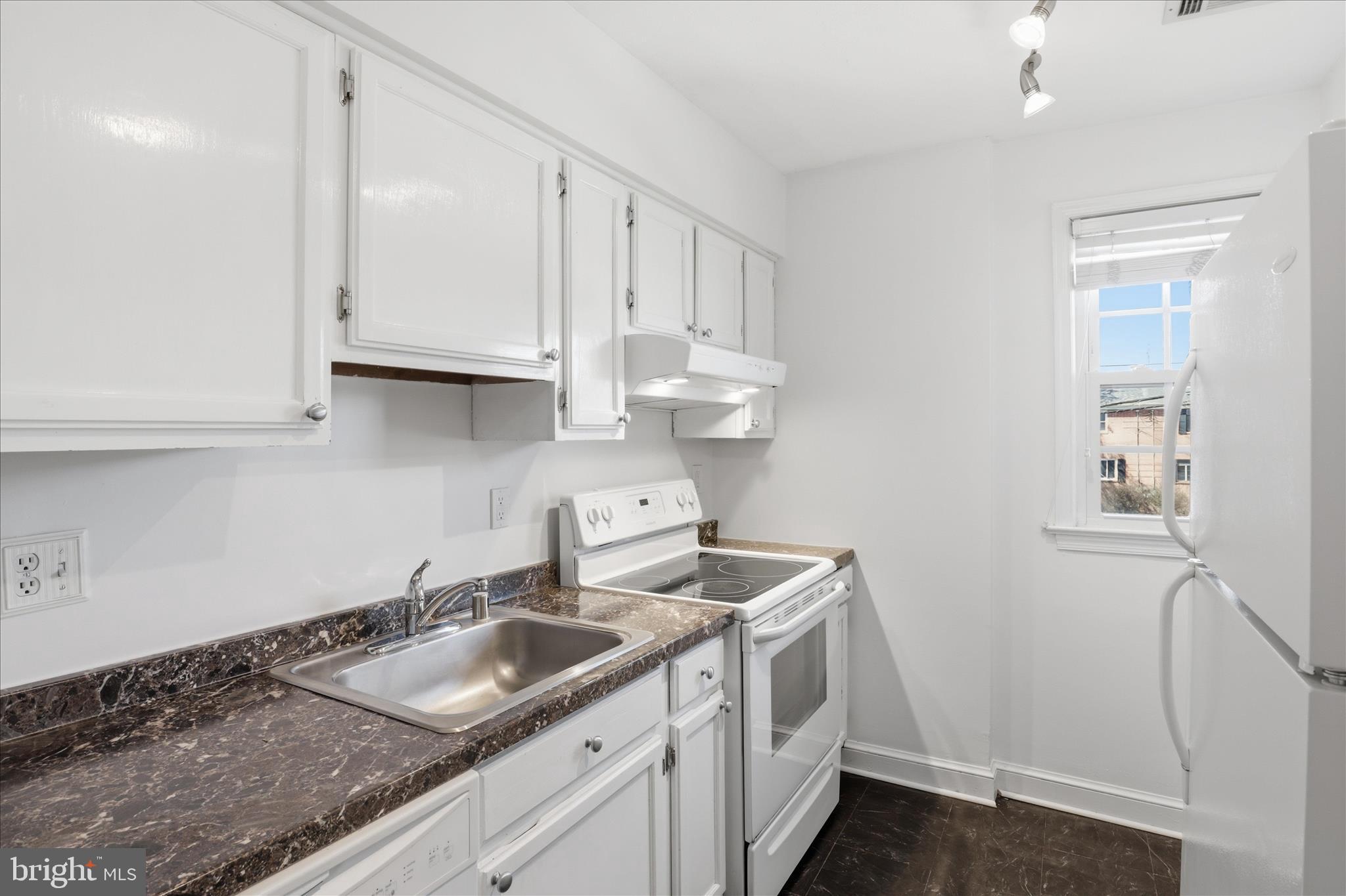 1305 South Walter Reed Drive, Unit 201 Arlington, VA 22204 - Photo 5 of 17 White cabinetry and generous counter space