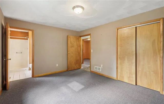 an empty room with windows and entrance to other room