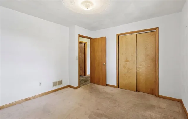 an empty room with windows and closet