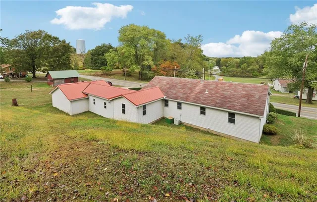 a view of a house with a yard and large tree